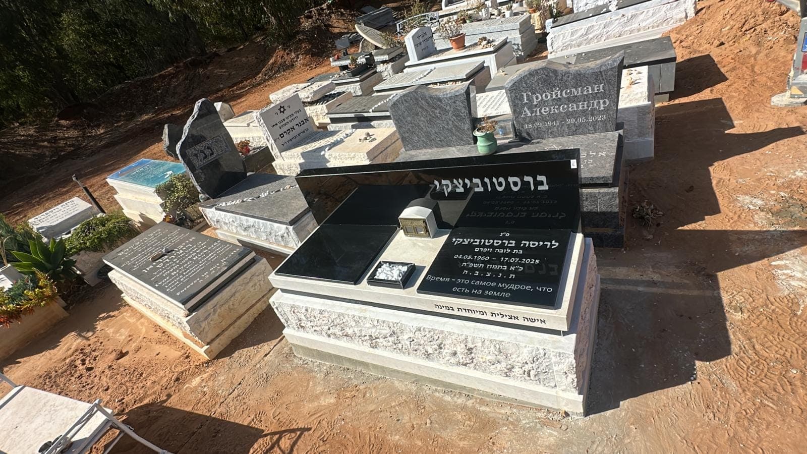 מצבת גרניט שחור על בסיס אבן מסותתת בבית עלמין